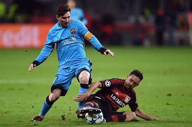 Leverkusen’s midfielder Karim Bellarabi ® vies with Barcelona´s Argentinian striker Lionel Messi during the Group E, second-leg UEFA Champions League football match Bayer 04 Leverkusen vs FC Barcelona. Photo: AFP