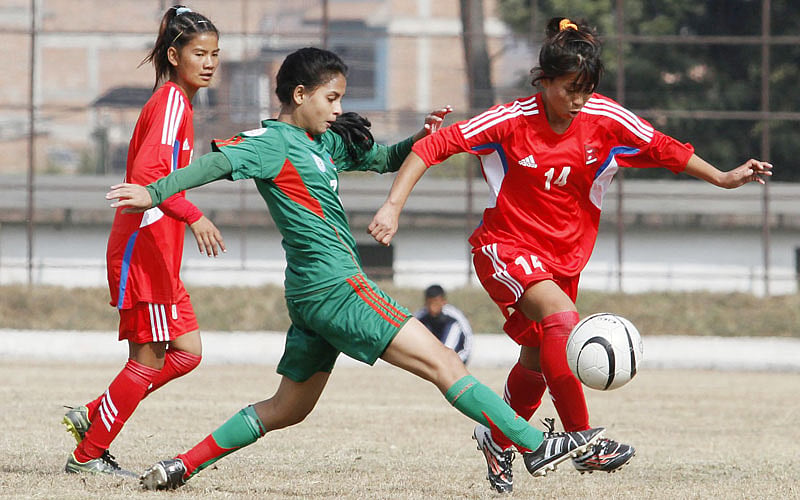 3.	Nepalese U-14 girls football player Manjali Kumari (R)and Bangladesh`s Sanjida Akhter (L) play during the AFC regional championship match in Kathmandu on December 20, 2015. Bangladesh won 1-0. AFP