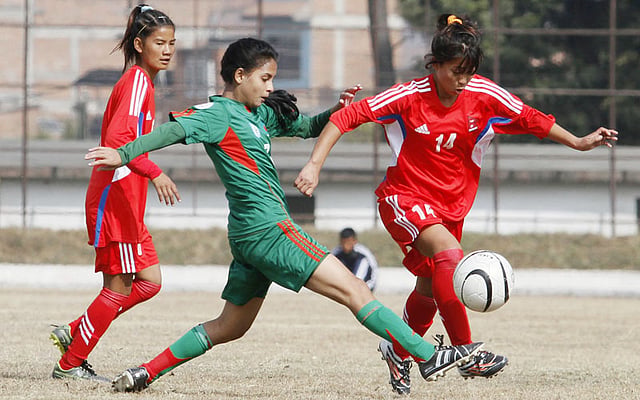3.	Nepalese U-14 girls football player Manjali Kumari (R)and Bangladesh`s Sanjida Akhter (L) play during the AFC regional championship match in Kathmandu on December 20, 2015. Bangladesh won 1-0. AFP
