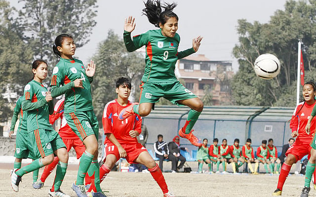 2.	Nepalese U-14 girls football players and Bangladesh`s Krishna Rani (C) play during the AFC regional championship match in Kathmandu on December 20, 2015. Bangladesh won 1-0. AFP
