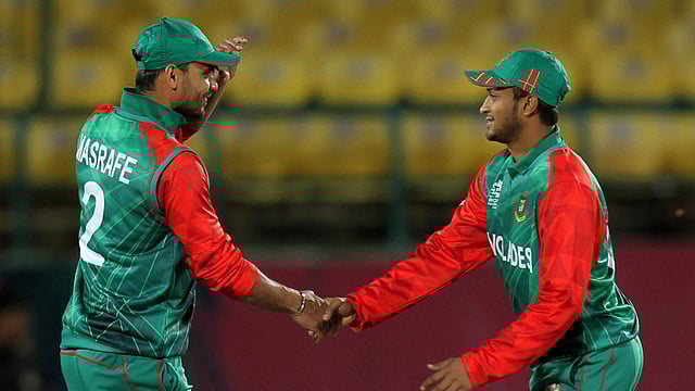 Bangladesh captain Masfrafe Bin Mortaza (L) and teammate Shakib Al Hasan shake hands after winning the qualifying match for the World T20 cricket tournament between Bangladesh and Oman at The Himachal Pradesh Cricket Association Stadium in Dharamsala on 13 March 13, 2016. Photo: AFP