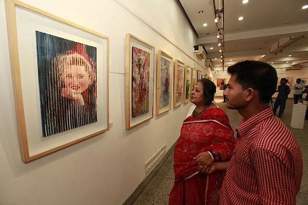 Visitors look at paintings at the solo art exhibition ‘Three Shadows of Art’ at Alliance Française de Dhaka on Friday. Photo: Prothom Alo