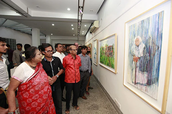Visitors look at paintings at the solo art exhibition ‘Three Shadows of Art’ at Alliance Française de Dhaka on Friday. Photo: Prothom Alo