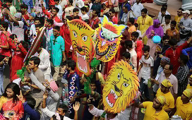 Clad in colourful attires, people carry flamboyant masks in the Mongol Shobhajatra on Pahela Baishakh in Dhaka on Thursday. Photo: Zahidul Karim