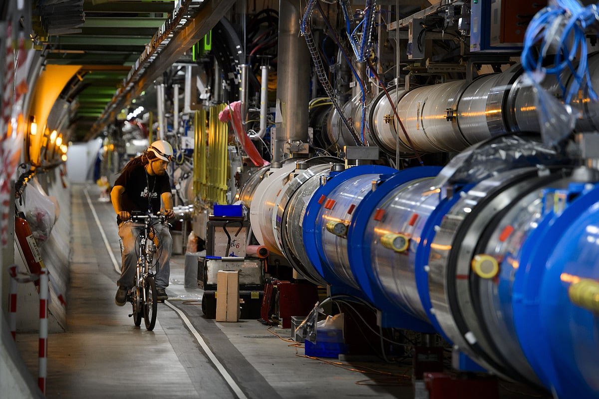 This file photo taken on 19 July, 2013 shows a worker riding his bicycle in a tunnel of the European Organisation for Nuclear Research (CERN) Large Hadron Collider (LHC), during maintenance works in Meyrin, near Geneva. Photo: AFP