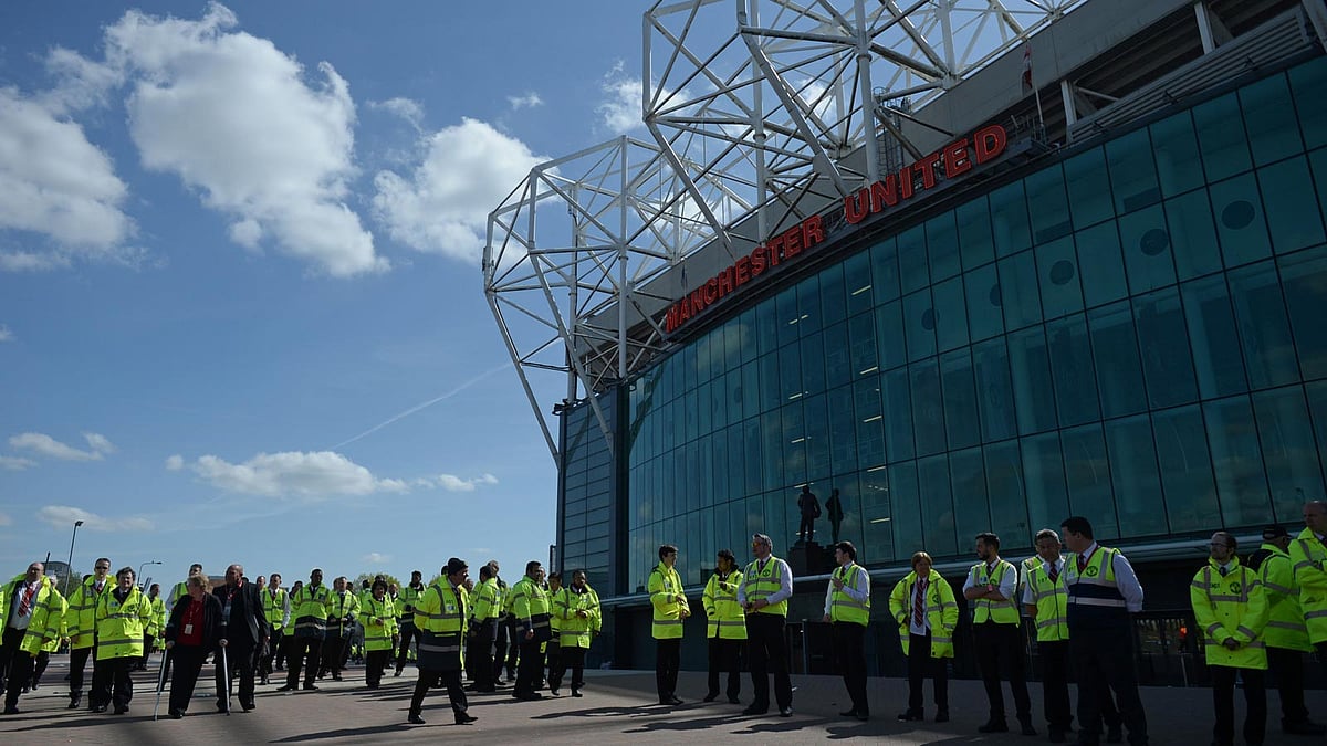 Evacuated stewards wait outside Old Trafford stadium in Manchester, England. Photo: AFP