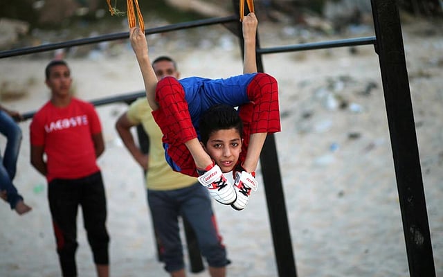 Palestinian boy Mohamad al-Sheikh, 12, who is nicknamed `Spiderman` and hopes to break the Guinness world records with his bizarre feats of contortion, demonstrates acrobatics skills in Gaza City June 2, 2016. Photo: Reuters