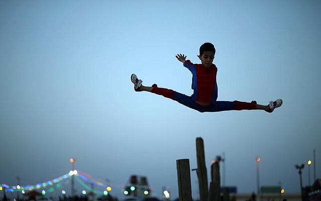 Palestinian boy Mohamad al-Sheikh, 12, who is nicknamed `Spiderman` and hopes to break the Guinness world records with his bizarre feats of contortion, demonstrates acrobatics skills on a beach in Gaza City June 2, 2016. Photo: Reuters