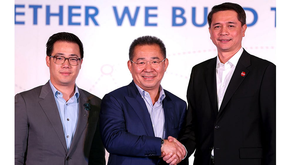 King Power CEO Aiyawatt Srivaddhanaprabha, chairman Vichai Srivaddhanaprabha and Thai Air Asia CEO Tassapon Bijleveld pose for photographs after a news conference at the King Power headquarters in Bangkok, Thailand on Tuesday. Reuters