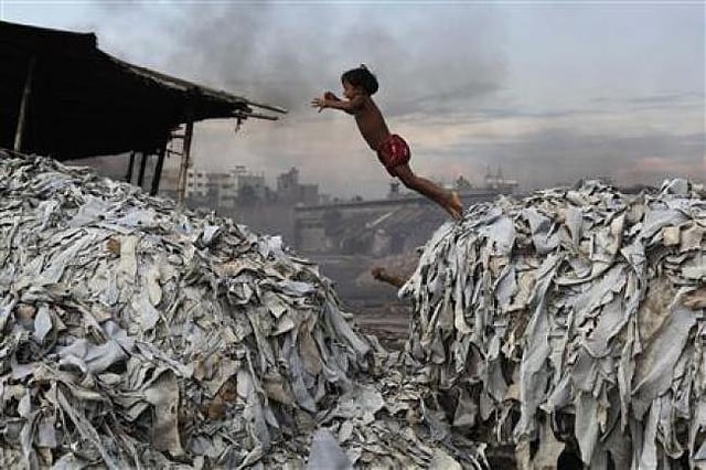 A child jumps on the waste products that are used to make poultry feed as she plays in a tannery at Hazaribagh in Dhaka October 9, 2012. Reuters file photo