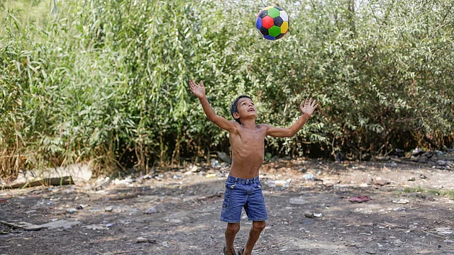 George Helmut Enache, one of the nine children of Gigel `Gica` Enache, plays with a football around the shack in which he lives along with his family, in the Vacaresti wetlands, in Bucharest, Romania. Photo : Reuters