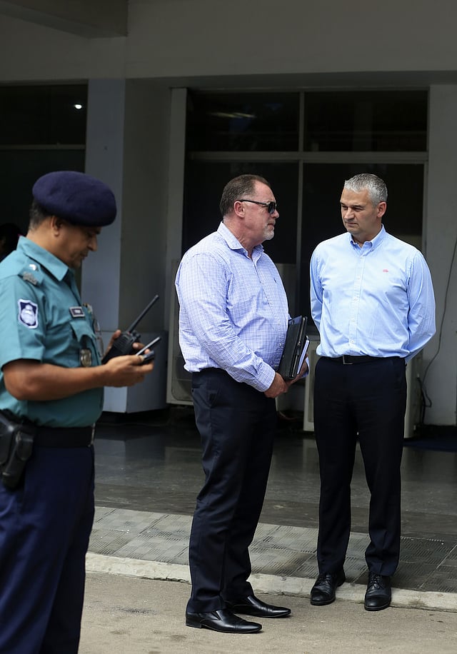 England Cricket Board (ECB) security advisor Reg Dickason (C) and Professional Cricketers Association(PCA) Chief Executive David Leatherdale (R) are watched by a Bangladeshi police official as they speak while standing at The Sher-e-Bangla Cricket Stadium at Mirpur in Dhaka on August 18, 2016. AFP