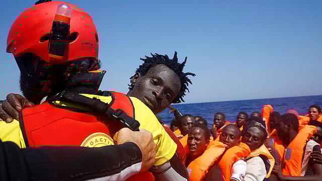 A migrant is carried from an overcrowded dinghy by a member of the Spanish NGO Proactiva during a rescue operation by the Spanish NGO Proactiva, off the Libyan coast in Mediterranean Sea August 28, 2016. Photo: Reuters