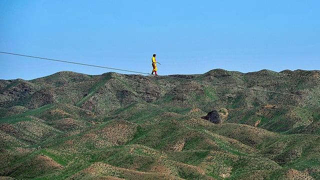 A man performs as he walks on a tightrope in Qingtongxia, Ningxia Hui Autonomous Region, China, August 26, 2016. Photo: Reuters