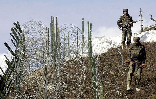This file photograph taken on December 4, 2003, shows Indian soldiers as they patrol along a barbed-wire fence near Baras Post on the Line of Control (LoC) between Pakistan and India some 174 kms north west of Srinagar. Photo: AFP