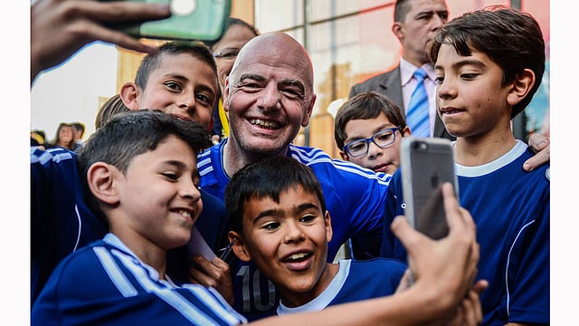 FIFA’s president Gianni Infantino takes selfies during a friendly football match with former Colombian players and international football stars in Bogota, on 3 October. Photo: AFP
