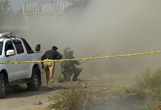 A Pakistani bomb disposal squad personnel gets off the floor after an improvised explosive device (IED) exploded during an disarmament operation in Peshawar on 25 October, 2016, after the killing of a policeman in an IED blast. Photo: AFP