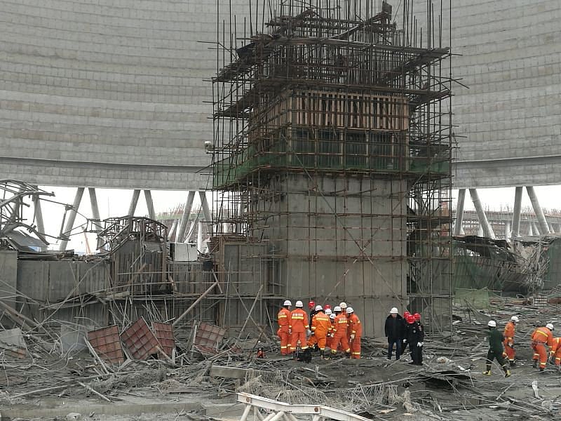 Rescue workers search the site where a power plant`s cooling tower under construction collapsed, in Fengcheng. Photo: Reuters