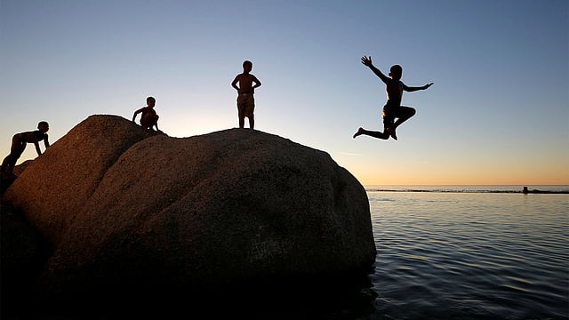 Children leap into a tidal pool as temperatures soar at Camps Bay beach in Cape Town, South Africa, December 11, 2016. Photo: Reuters