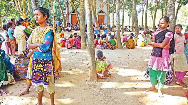 Members of Santal community gather before a Church after their homesteads were set on fire. File Photo