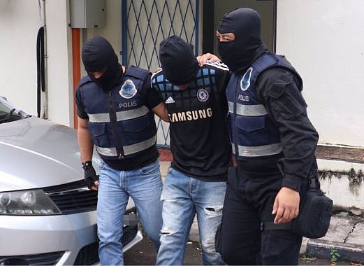 One of the suspects, arrested by police. Photo: The New Strait Times