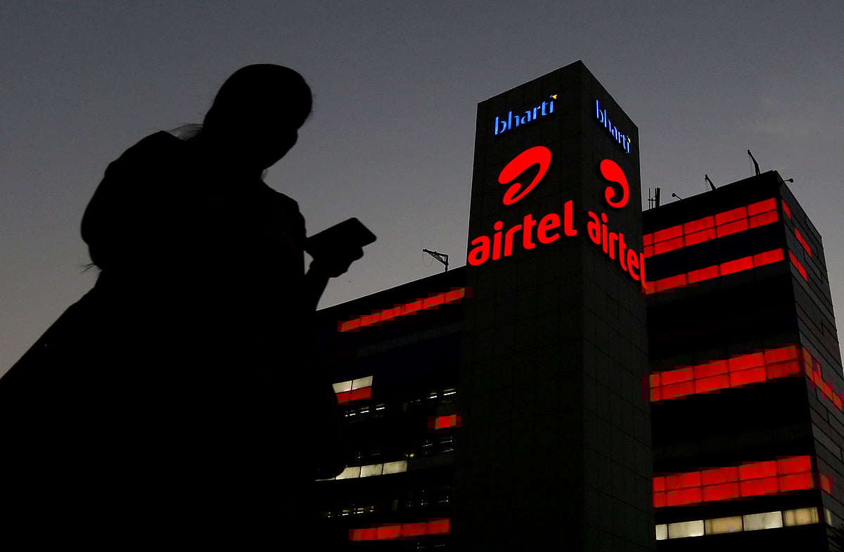 A girl checks her mobile phone as she walks past the Bharti Airtel office building in Gurugram. Photo: Reuters