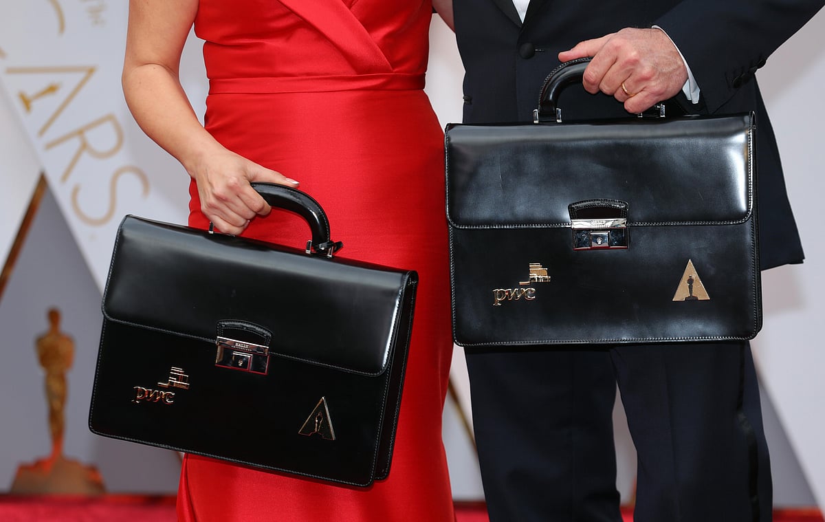Martha Ruiz (L) and Brian Cullinan of PricewaterhouseCoopers hold briefcases containing the winners on the red carpet. Photo: Reuters