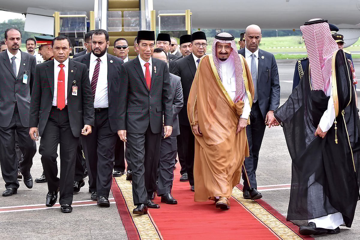 This picture from the Indonesian Presidential Palace taken and released on March 1, 2017 shows Indonesia's President Joko Widodo (centre L) escorting Saudi Arabia's King Salman bin Abdul Aziz upon his arrival at Halim airport in Jakarta. AFP