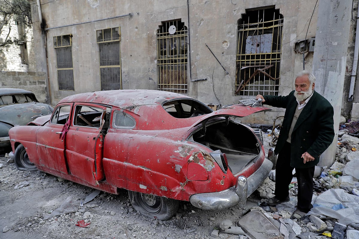 70-year-old Mohammad Mohiedine Anis opening the trunk of his 1949 Hudson Commodor outside his home in Aleppo’s formerly rebel-held al-Shaar neighbourhood. Photo: AFP