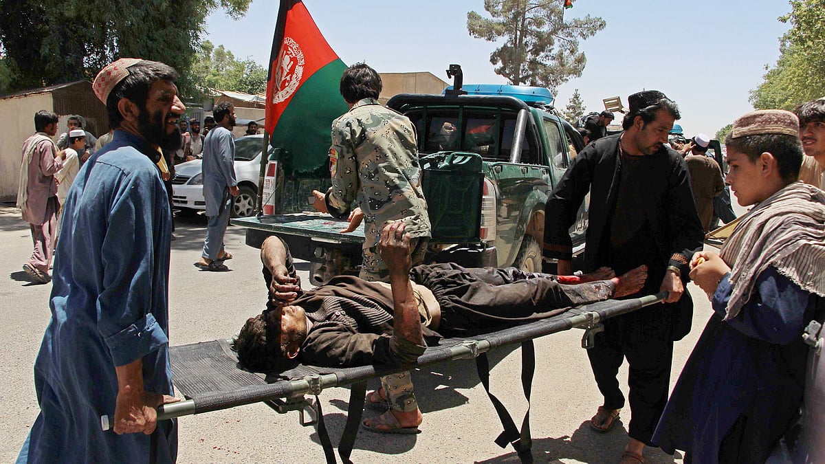 Afghan men carry a victim of a powerful car bomb in Lashkar Gah, the capital of Helmand province, on 22 June, 2017. Photo: AFP