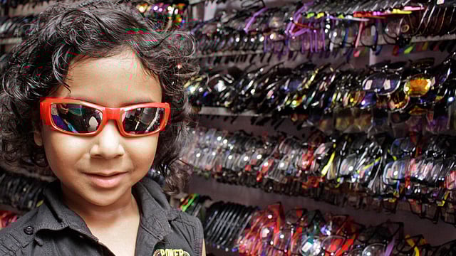 A boy buys a sunglass matching his new dresses for Eid at Chittagong New Market area on Friday. Photo: Jewel Shil
