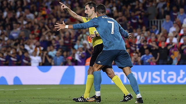 Cristiano Ronaldo (R) gestures after receiving a red card by referee Ricardo de Burgos Bengoetxea during the first leg of the Spanish Supercup football match between FC Barcelona and Real Madrid CF at the Camp Nou stadium in Barcelona. Photo: AFP