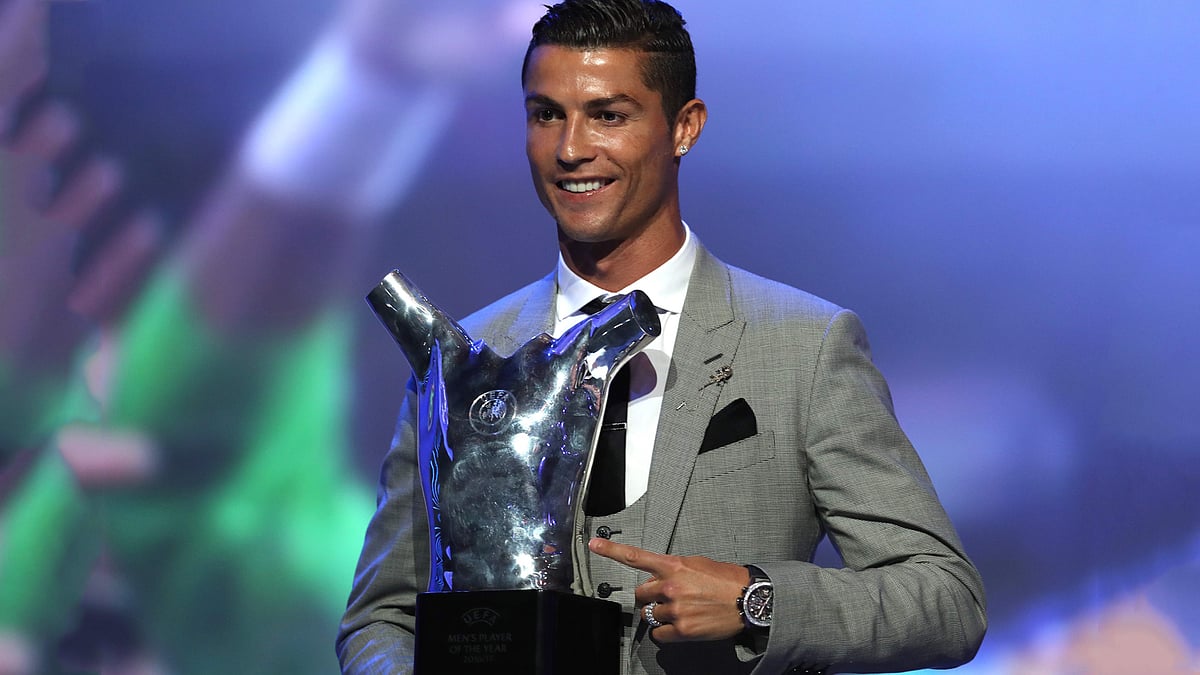 Real Madrid`s Portuguese forward Cristiano Ronaldo gestures as he poses with the trophy after he was awarded the title of `Best Men`s Player in Europe` at the conclusion of the UEFA Champions League group stage draw ceremony in Monaco on 24 August, 2017. Photo: AFP
