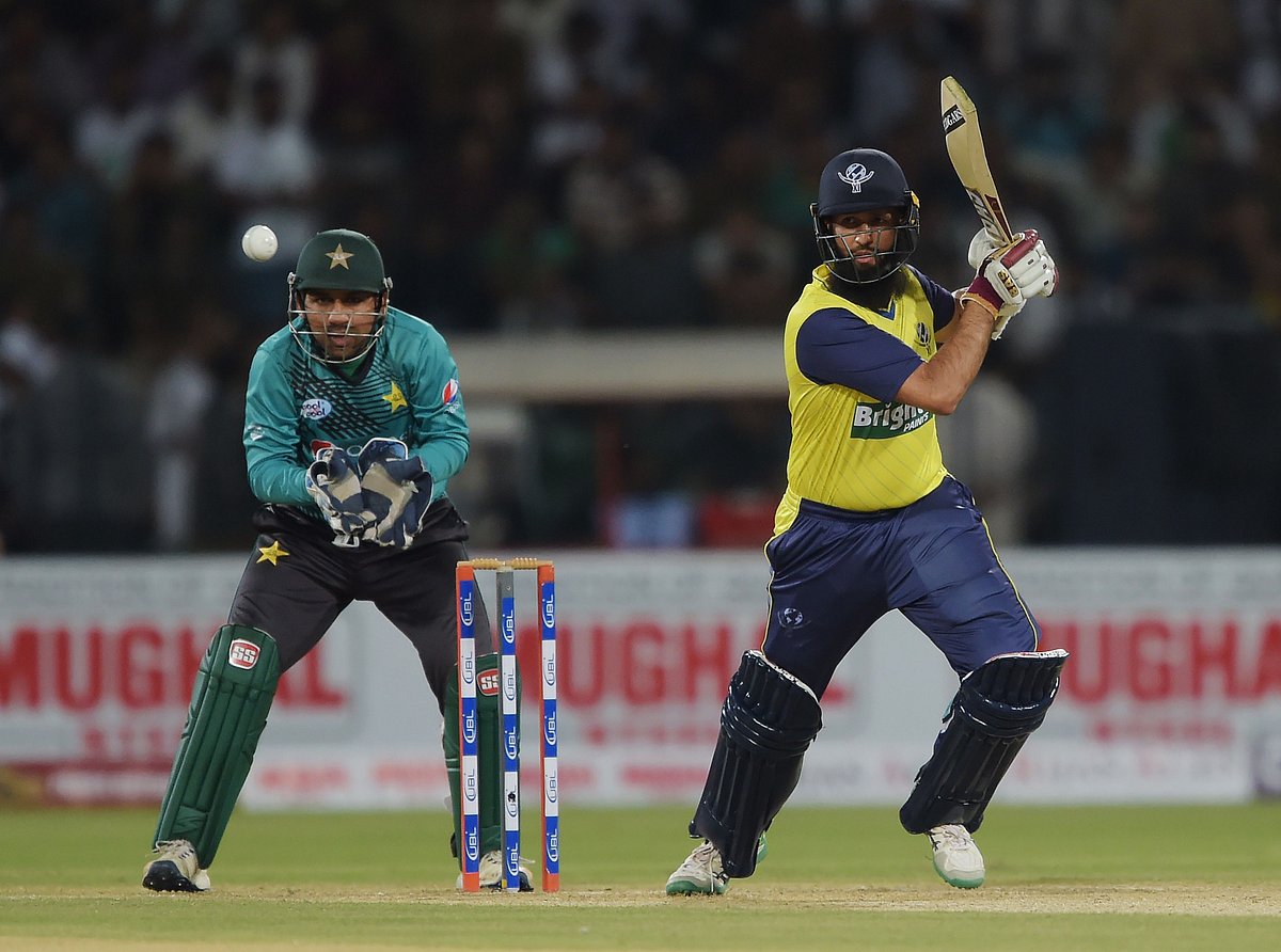 World XI batsman Hashim Amla (R) plays a shot as Pakistani captain and wicketkeeper Sarfraz Ahmad looks on during the second Twenty20 International match at the Gaddafi Cricket Stadium in Lahore on September 13, 2017. Photo: AFP