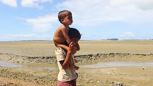 Young Rohingya going towards Teknaf, carrying little brother on his shoulders. Picture taken Thursday at Hariakhali. Photo: Abdus Salam
