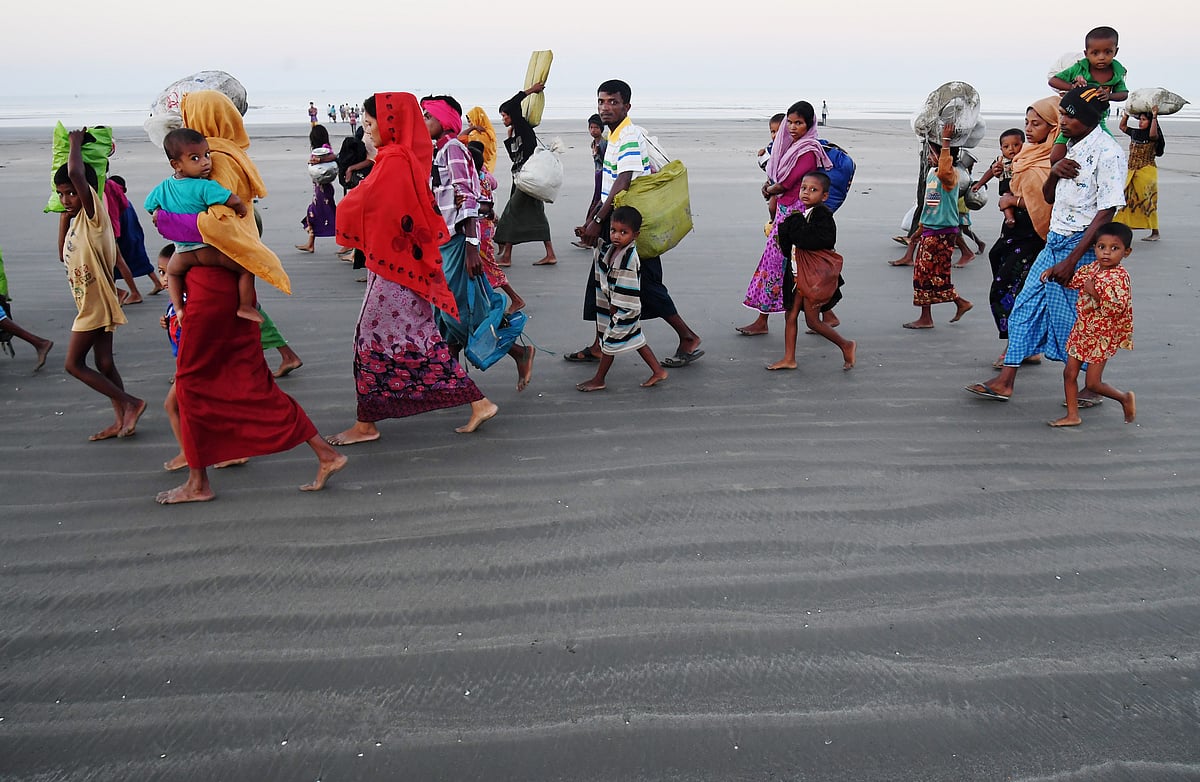 Rohingya Muslim refugees who entered Bangladesh by boat walk towards refugee camps after landing at the Saplapur beach in the Teknaf district of Bangladesh on November 9, 2017.  AFP