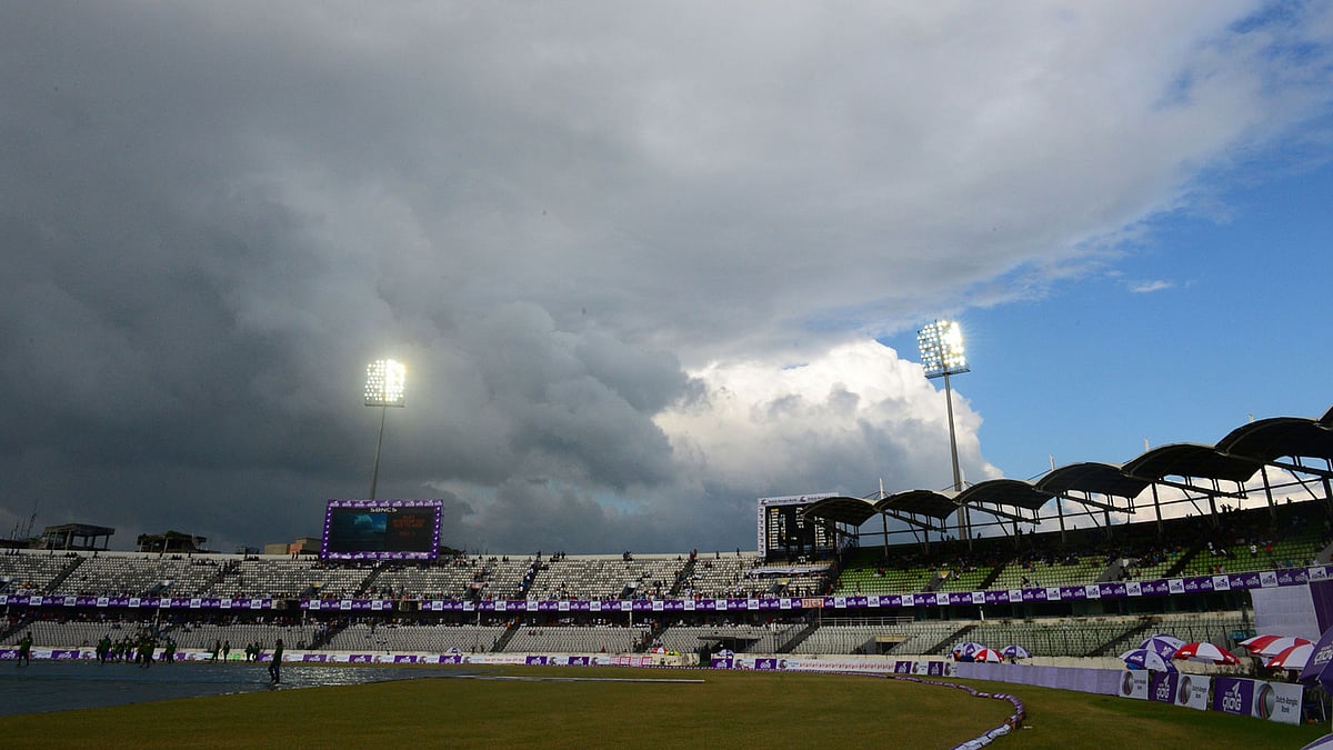 In this photograph taken on 27 August, 2017, Bangladeshi ground staff cover the pitch as rain approaches during the first day of the first Test cricket match between Bangladesh and Australia at the Sher-e-Bangla National Cricket Stadium in Dhaka. Photo: AFP