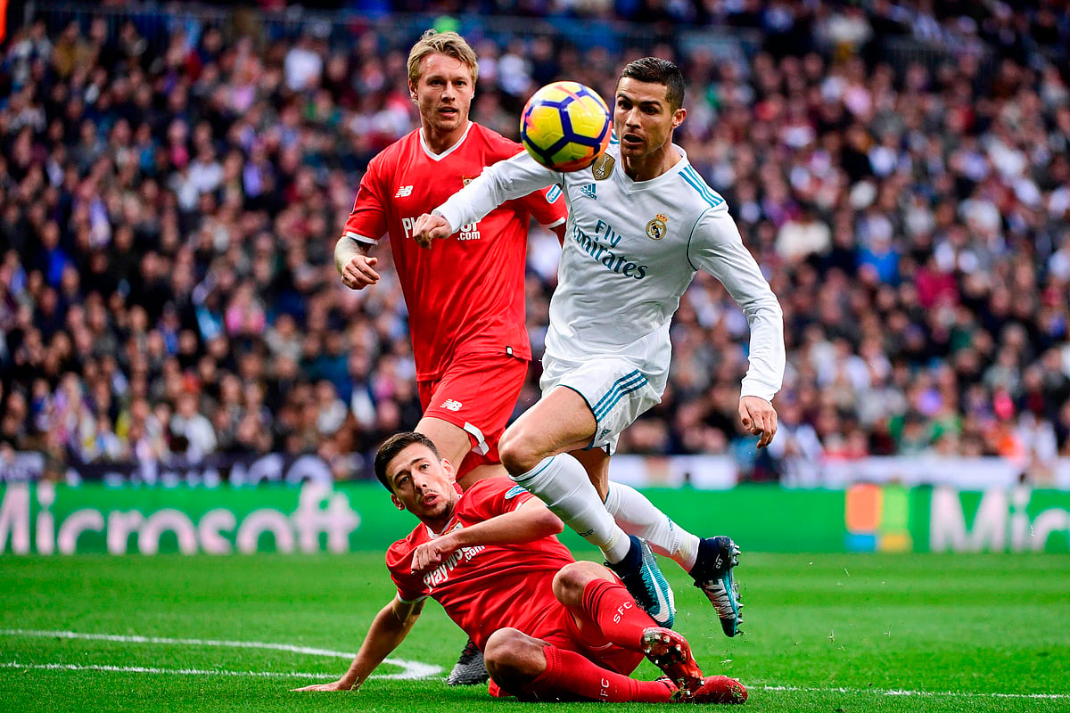 Real Madrid's Portuguese forward Cristiano Ronaldo (R) challenges Sevilla's French defender Clement Lenglet (C) and Sevilla's Danish defender Simon Kjaer (back) during the Spanish league football match between Real Madrid and Sevilla at the Santiago Bernabeu Stadium in Madrid on 9 December, 2017. Photo: AFP