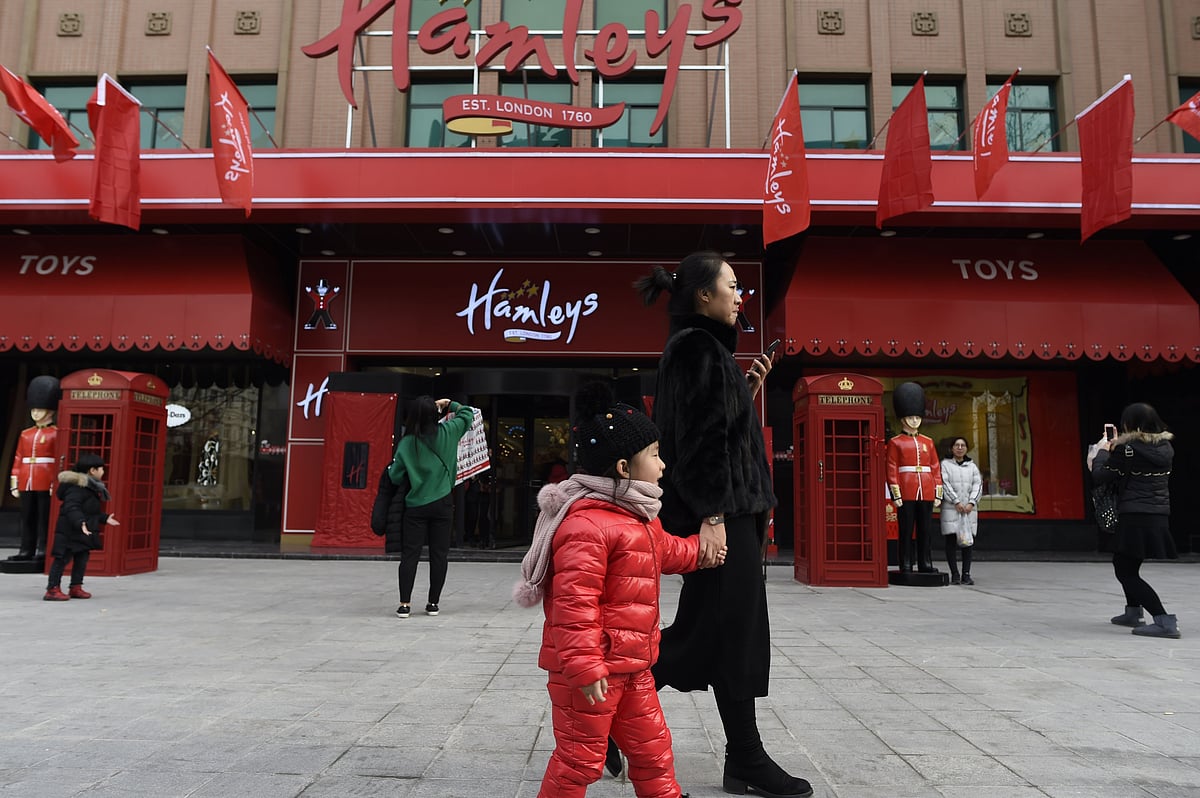 A family walks past on the opening day of a new Hamleys store, the iconic British toy retailer now Chinese-owned, in Beijing. Photo: AFP