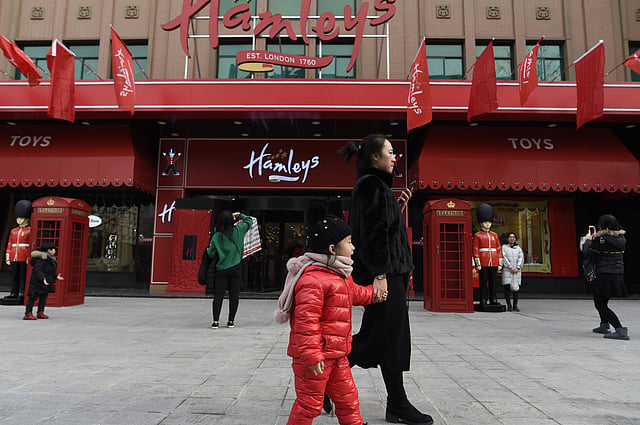 A family walks past on the opening day of a new Hamleys store, the iconic British toy retailer now Chinese-owned, in Beijing. Photo: AFP