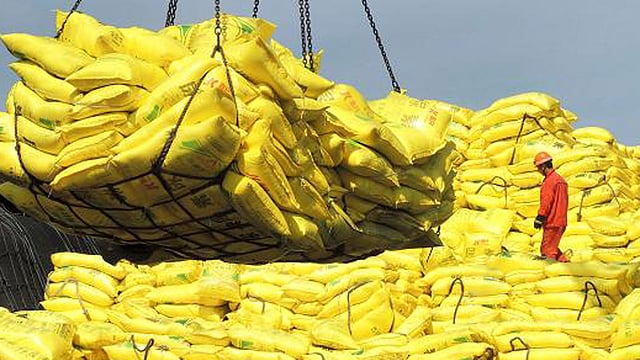 A worker stands on piles of industrial products before exporting, at a port of Lianyungang, China. Reuters