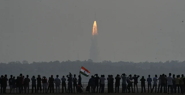 People watch as Indian rocket Polar Satellite Launch Vehicle (PSLV) lifts off successfully from Sriharikota with a record 104 satellites, including the country`s earth observation satellite Cartosat-2 series; at Marina Beach, Chennai on 15 Feb 2017.
