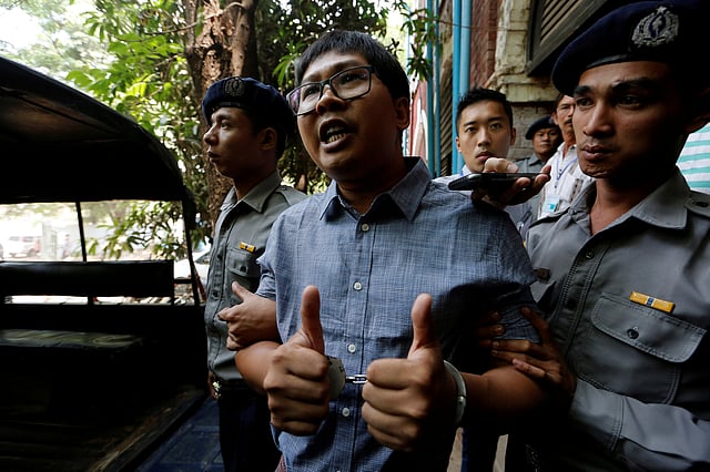 Detained Reuters journalist Wa Lone is escorted by police after a court hearing in Yangon. Photo: Reuters