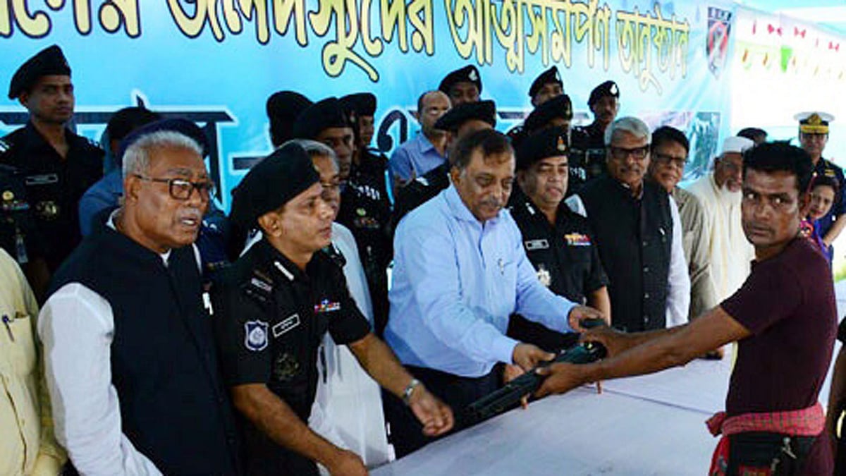 A member of Sundarbans forest robber gangs surrenders to home minister Asaduzzaman Khan at Labonchora on Wednesday. Photo: UNB