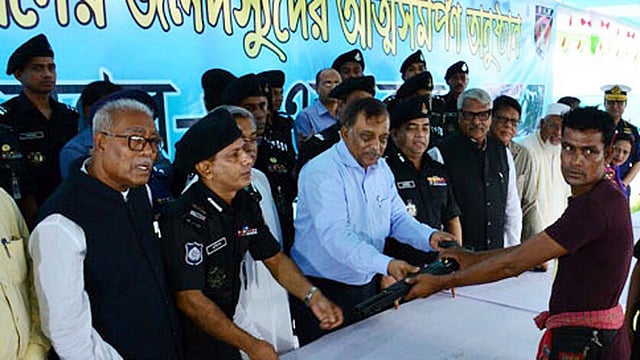 A member of Sundarbans forest robber gangs surrenders to home minister Asaduzzaman Khan at Labonchora on Wednesday. Photo: UNB