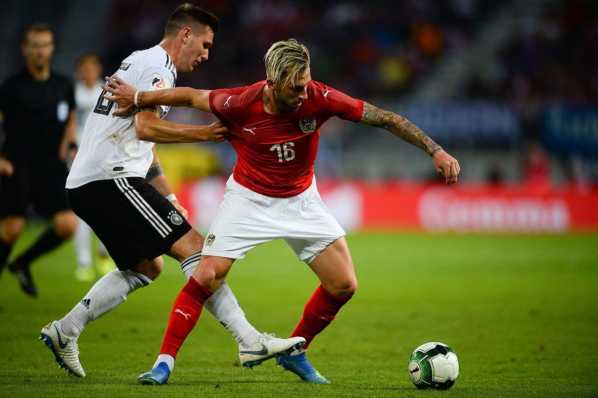 Austria`s midfielder Peter Zulj (R) and Germany`s defender Niklas Suele vie for the ball during the international friendly footbal match in Klagenfurt, Austria, on 2 June 2018. Photo: AFP