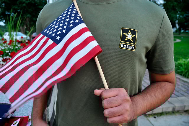 In this 3 July, 2018, photo, a Pakistani recruit, 22, who was recently discharged from the US Army, holds an American flag as he poses for a picture. The man asked his name and location to be undisclosed for safety reasons. Photo: AP