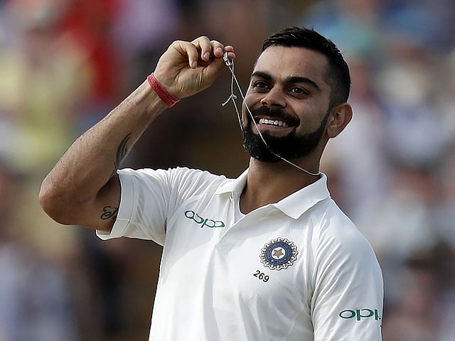 India`s captain Virat Kohli holds his wedding ring as he celebrates scoring his century on the second day of the first Test cricket match between England and India at Edgbaston in Birmingham, central England on 2 August, 2018. Photo: AFP
