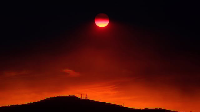 The sun sets under a cloud of smoke caused by a wildfire fanned by strong winds on the island of Evia, in Athens, Greece on 12 August. Photo: Reuters