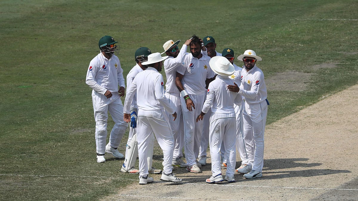 Pakistan cricketer Bilal Asif (C) celebrates with teammates after taking the wicket of Australian batsman Usman Khawaja during the third day of play of the first Test cricket match at the Dubai International Stadium in Dubai on 9 October 2018. Photo: AFP